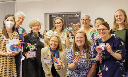 Nurse researchers stand in group each holding a colorful art object meant to symbolize their personal mottos