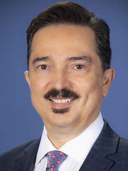 Portrait of a man with dark hair, mustache, and wearing a white shirt, tie and blue blazer
