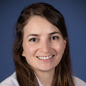 A female medical doctor in a white coat with brown hair. 