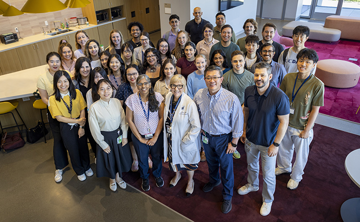 Dr. Aijun Wang and Dr. Diana Farmer standing with a group of scientists, looking up to the camera. 