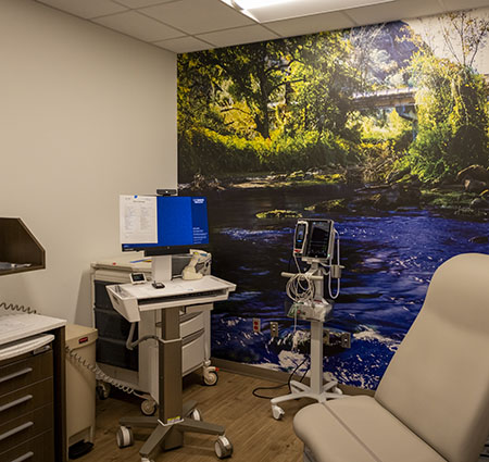 A medical office with a chair and a decorative wallpaper design. 