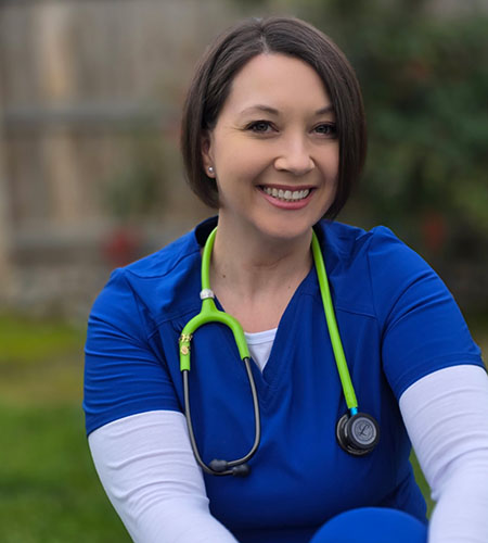 A woman in blue scrubs with a stethoscope around her neck