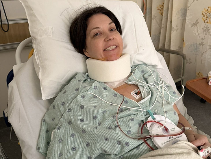 A woman in a hospital bed wearing a neck brace