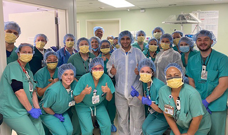 A large group of people in scrubs pose for a photo.