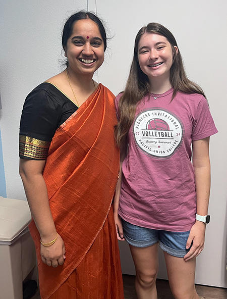 Woman stands next to teenage girl