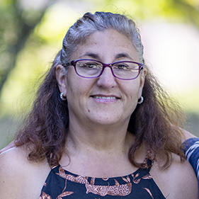 Headshot of a woman in a sleeveless flower dress
