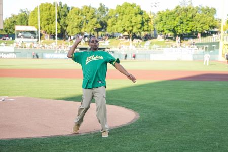 Man in green jersey throwing baseball with right hand.
