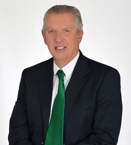 Man with grayish hair wearing a suit poses for a portrait