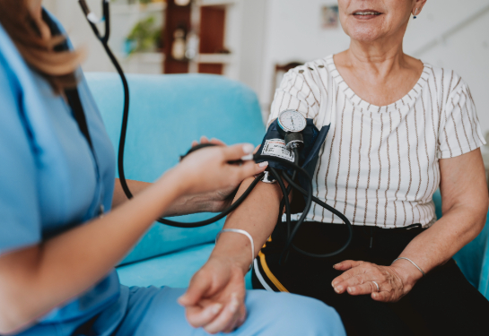 Home care healthcare professional measuring blood pressure