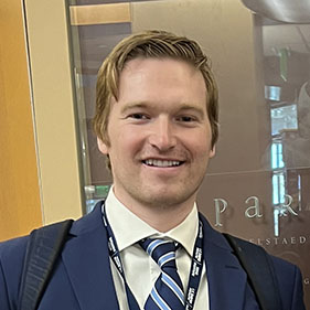 A man in a suit smiles for a portrait