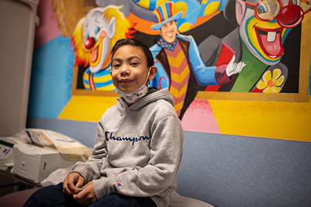 Young Hispanic boy with black hair in hospital clinic.