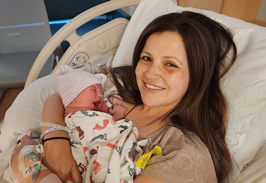 Woman in hospital bed holding newborn.