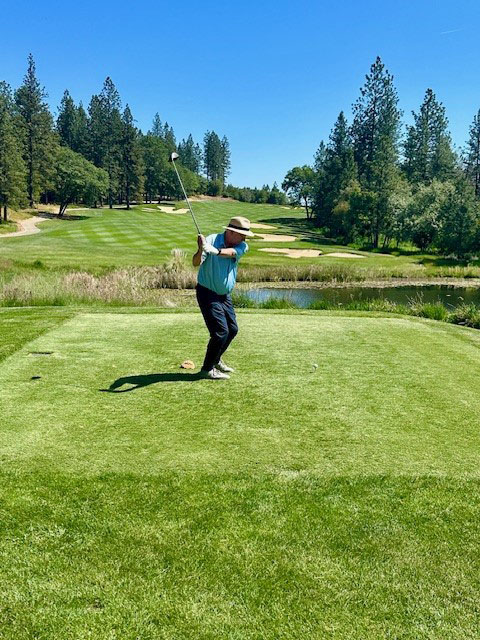 a man golfs on a grassy course. 