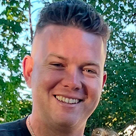 Headshot of smiling man with brown hair.