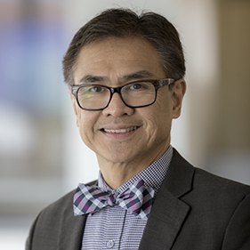 A man in a brown suit with a bowtie. 