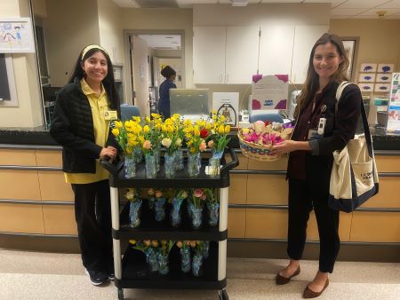 CARE Project volunteer and Katie Lorain passing out flowers on Mother's Day to patients in the hospital