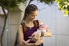 Brown haired woman - mom - holding her baby daughter