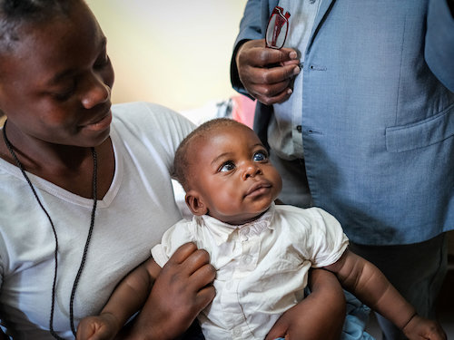 A woman holds a baby on her lap at the University Teaching Hospital – Eye Hospital in Lusaka, Zambia. 
