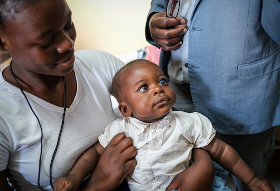 A woman holds a baby on her lap at the University Teaching Hospital – Eye Hospital in Lusaka, Zambia. 