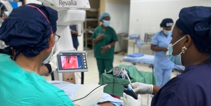 Two physicians in an operating room look at a screen showing the patient&rsquo;s airway. 