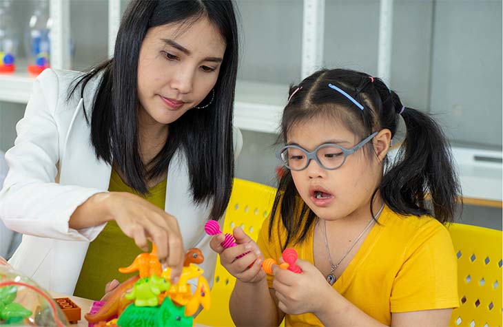 woman standing at a table covered in brochures talking to attendees