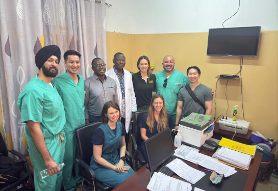 Group of doctors standing together behind a desk.