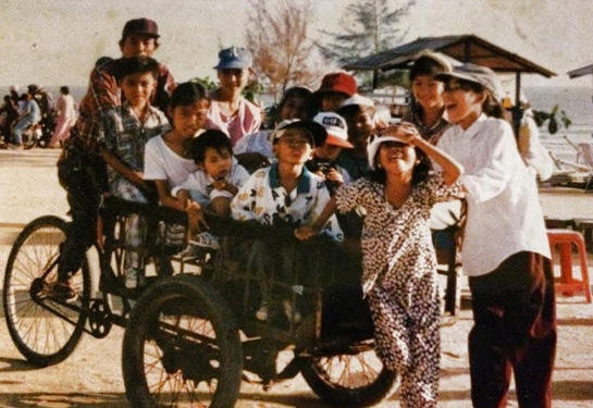 historical photo of Vietnamese family riding a bike and running in the street