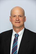 James Holmes wearing white coat.