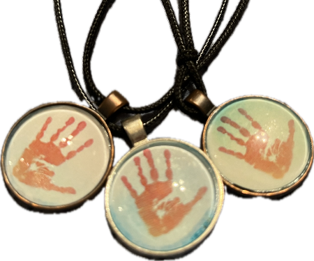 Image of handprints scaled down to create necklaces for each family member