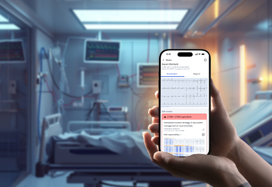 A hand holding a smartphone with an ECG report, inside a hospital room with medical monitors and a patient bed in the background.